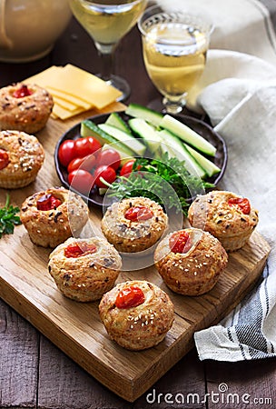 Muffins with cheese, cottage cheese and tomatoes, vegetables and cheese served with wine Stock Photo