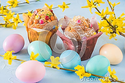 Muffins with chocolate, colorful Easter eggs and forsythia branches Stock Photo