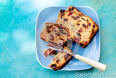 Muffins with raisins on a rustic wooden table. Fruitcake or slices cupcake on a blue plate. Stock Photo