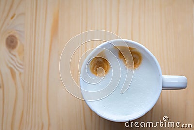 Mug with coffee and air milk stands on wooden brown table Stock Photo