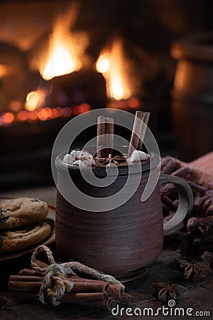 Mug of hot chocolate with fireplace burning in background Stock Photo