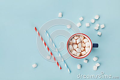 Mug of hot cocoa or chocolate and straw on turquoise table top view. Flat lay. Stock Photo