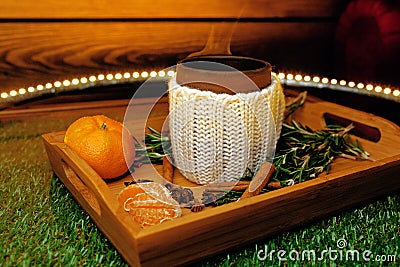 A mug of warm tea with pieces of manadarines on a wooden tray Stock Photo