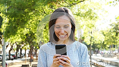 Mujer adulta usando el teléfono elegante en un parque Mujer adulta usando el teléfono elegante en un parque