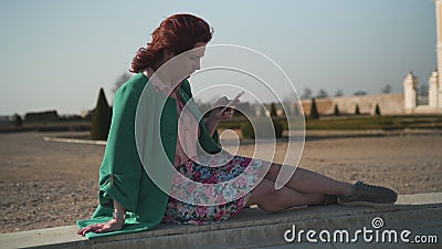 Mujer joven adicta de la moda que lleva el sol de goce levantado verde en una fuente delante de un palacio almacen de video Mujer joven adicta de la moda que lleva el sol de goce levantado verde en una fuente delante de un palacio almacen de video