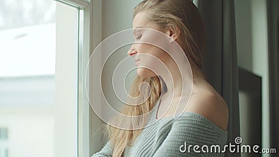 Mujer pensativa joven que hace una pausa una ventana metrajes Mujer pensativa joven que hace una pausa una ventana metrajes