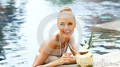 Mujer rubia adorable que se coloca en piscina Mujer rubia adorable que se coloca en piscina