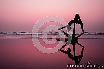 Muladhara swadhisthana manipula tantra yoga on the beach man and woman meditates sitting on the sand by the sea at Stock Photo