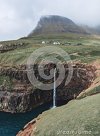 Mulafossur Waterfall pours over the cliffs from Gasadalur Stock Photo