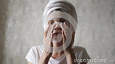 Mulher caucasiana com máscara humedecedora no rosto bate uma toalha branca na cabeça e olha para a câmera Limpeza vídeos de arquivo Mulher caucasiana com máscara humedecedora no rosto bate uma toalha branca na cabeça e olha para a câmera Limpeza vídeos de arquivo