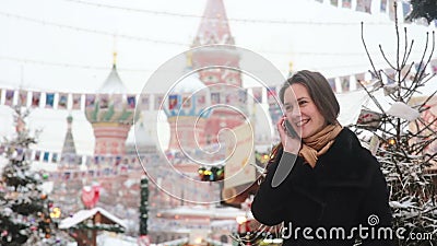 Mulher que fala no telefone que está no inverno no quadrado vermelho em Moscou, na frente de St Basil Cathedral video estoque Mulher que fala no telefone que está no inverno no quadrado vermelho em Moscou, na frente de St Basil Cathedral video estoque