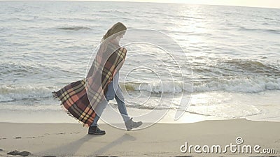 Mulher só que anda no Sandy Beach com manta Tempo de gasto fêmea novo na costa do mar no dia frio filme Mulher só que anda no Sandy Beach com manta Tempo de gasto fêmea novo na costa do mar no dia frio filme