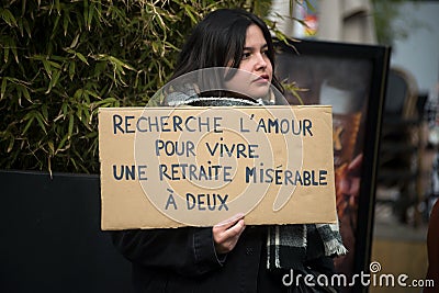 woman protesting with placard in french : cherche l'amour pour vivre une retraite miserable a Editorial Stock Photo