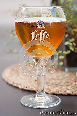 Closeup of glass of beer from Leffe brand on the table of restaurant terrace Editorial Stock Photo
