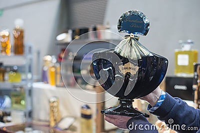 Big bottle perfume of Shalimar by Guerlain in hands of collector at the flea market Editorial Stock Photo