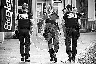 Municipal police women and police man walking in main place on back view Editorial Stock Photo