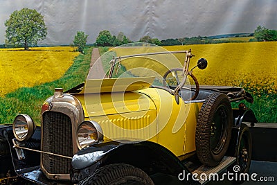 Old car in front of a photo of yellow fields Editorial Stock Photo