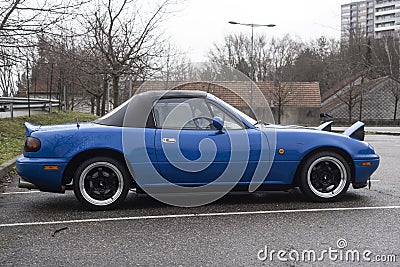 Profile view of vintage Mazda MX5 parked in the street by rainy day Editorial Stock Photo