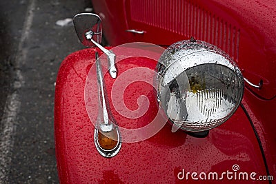 Closeup of rain drops on headlight of red Citroen traction parked in the street Editorial Stock Photo