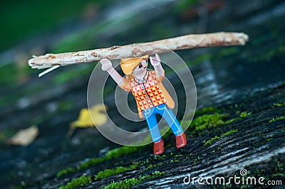 Playmobil figurine carrying a tree trunk above the head on wooden floor Editorial Stock Photo