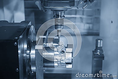 The multi-axis CNC milling machine tapping the thread at the aluminium casting parts by tapping tool . Stock Photo