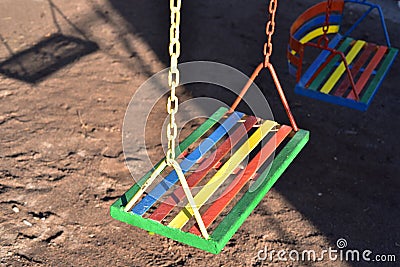 Multi-color painted swing for child on playground Stock Photo