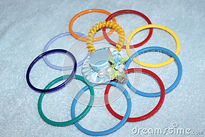 Multi-colored children`s bracelets and hairpin in the form of a blue hat. Stock Photo