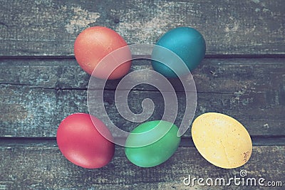 Multi-colored eggs painted with gouache and onion peel close up on wooden background. Five boiled eggs. Postcard poster Stock Photo
