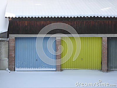 Multi colored garage door and snow in front of a garages Stock Photo