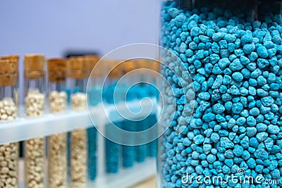 Multi-colored granules of micronutrient fertilizer in test tubes in a row Stock Photo