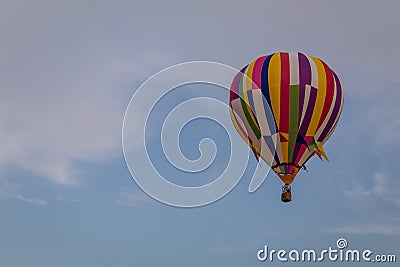 Multi-colored hot air balloon floats through the sky at dusk at Warren County Farmer`s Fair, Harmony, New Jersey, on 8/1/17 Editorial Stock Photo