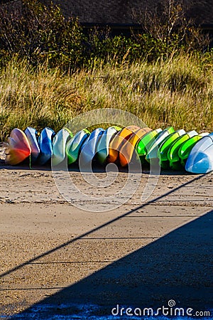 Multi-colored Kayaks Stored on the Sand by the Pier Stock Photo