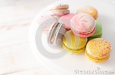 Multi-colored macarons close up on wood background with soft lights. French dessert for breakfast in the morning light Stock Photo