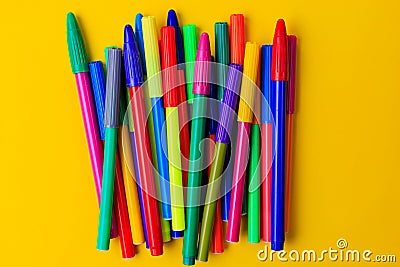 Multi-colored markers with mixed caps. Creative concept. Yellow background with selective focus and copy space Stock Photo
