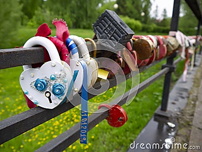 Multi-colored padlocks with keys thrown into the river. Stock Photo