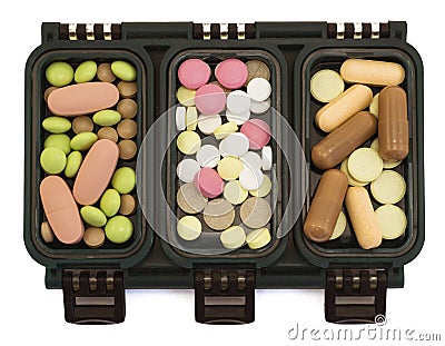 Multi-colored pills in green box organizer filtered Stock Photo