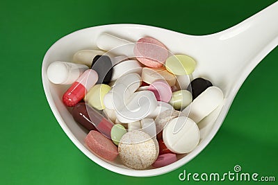 Multi colored pills in white spoon Stock Photo