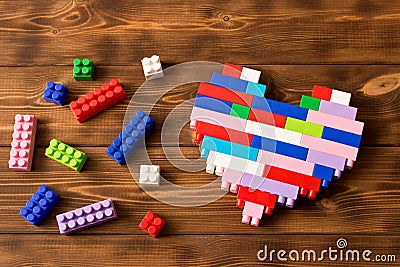 Multi-colored plastic construction set on the wooden table . Children`s educational games. Close up Stock Photo