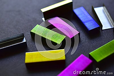 Multi-colored stapler staples on a black background Stock Photo