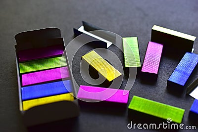 Multi-colored stapler staples on a black background Stock Photo