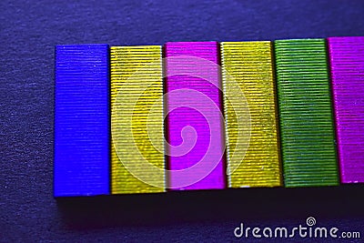 Multi-colored stapler staples on a black background Stock Photo