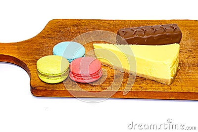 Multi Coloured sweets isolated on white background. Milk chocolate bar, colored macaroons and lemon cheesecake Stock Photo