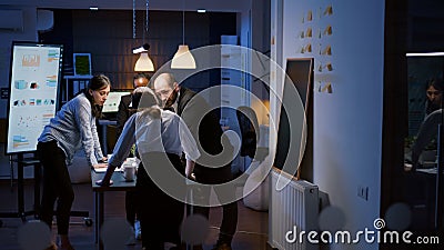 Multi ethnic businesspeople teamwork standing at conference table analyzing management graphs Stock Photo