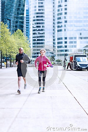 Multi-ethnic Couple Jogging In Urban Setting Stock Photo