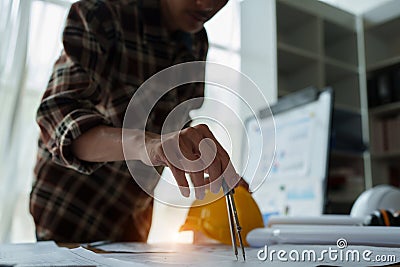 multi ethnic engineer brainstorming and measuring for cost estimating on blueprint and floor plan drawings about design Stock Photo
