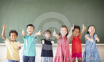 Multiethnic group of school children standing in classroom Stock Photo