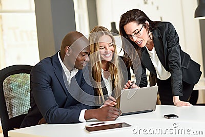 Multi-ethnic group of three businesspeople meeting in a modern o Stock Photo