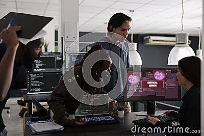 Multi ethnic programmers having security breach alert on computer screen Editorial Stock Photo