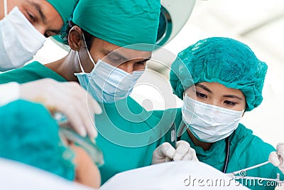 Multi-ethnic surgeons during a surgery Stock Photo