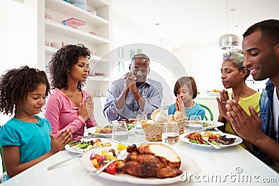 Multi Generation African American Family Praying At Home Stock Photo